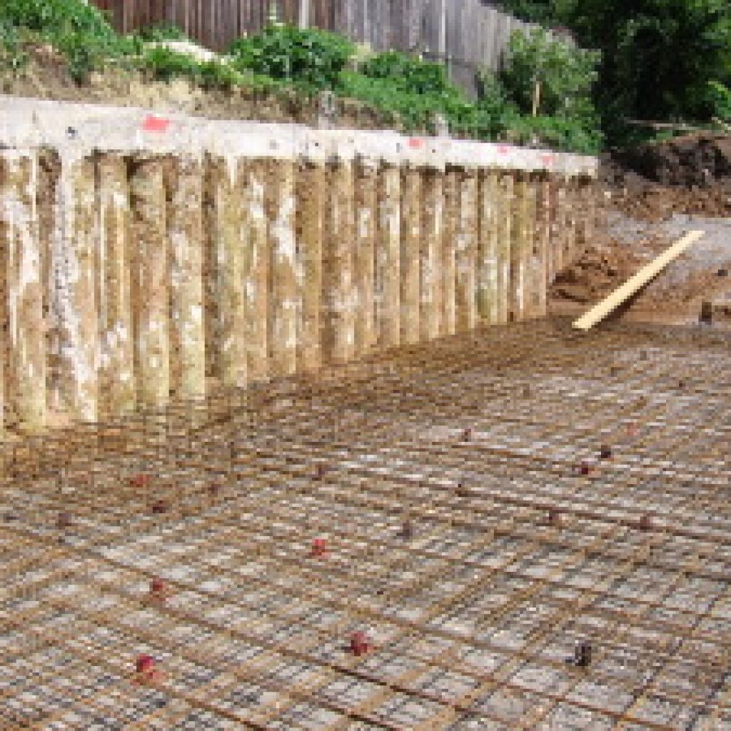 In order to create a basement on an infill site between two existing houses a continuous reinforced concrete piled retaining wall with capping beam was constructed by Underpin & Makegood Group.